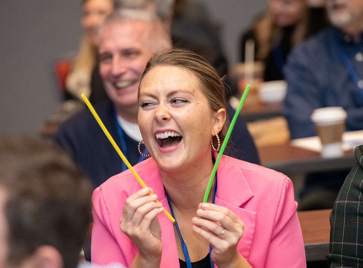 Staff member smiling holding colorful pipe cleaners